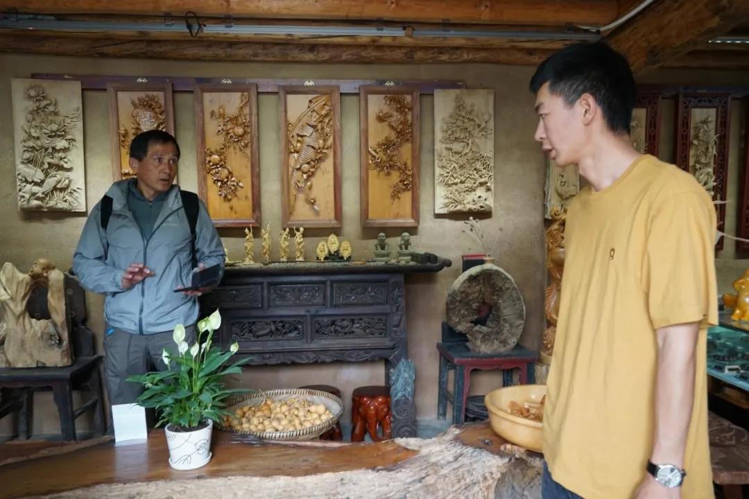 树新木雕体验馆的老板小罗与顾客交谈